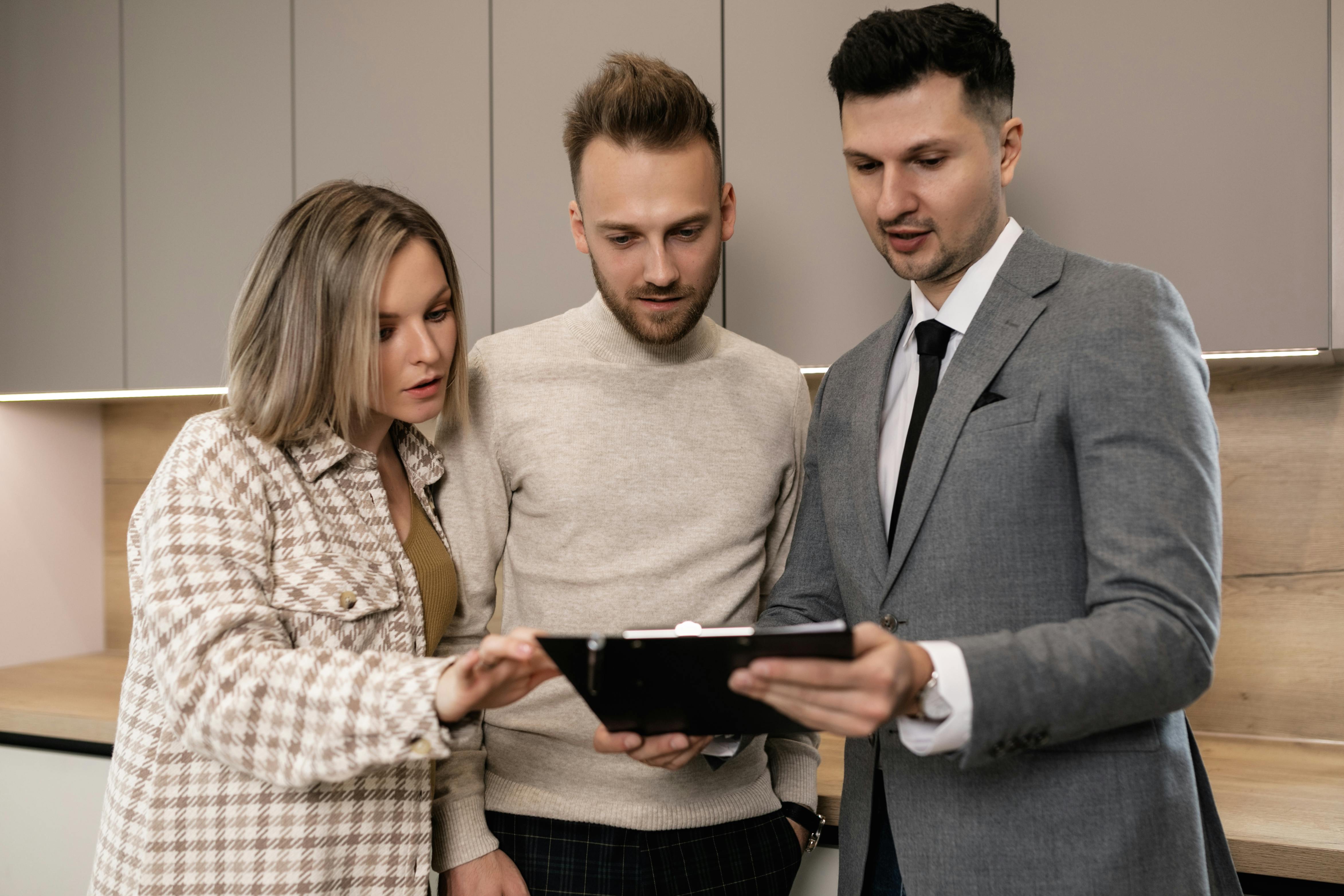 Real estate agent using mobile software with clients - real estate software Real estate agent using mobile software with clients - real estate software